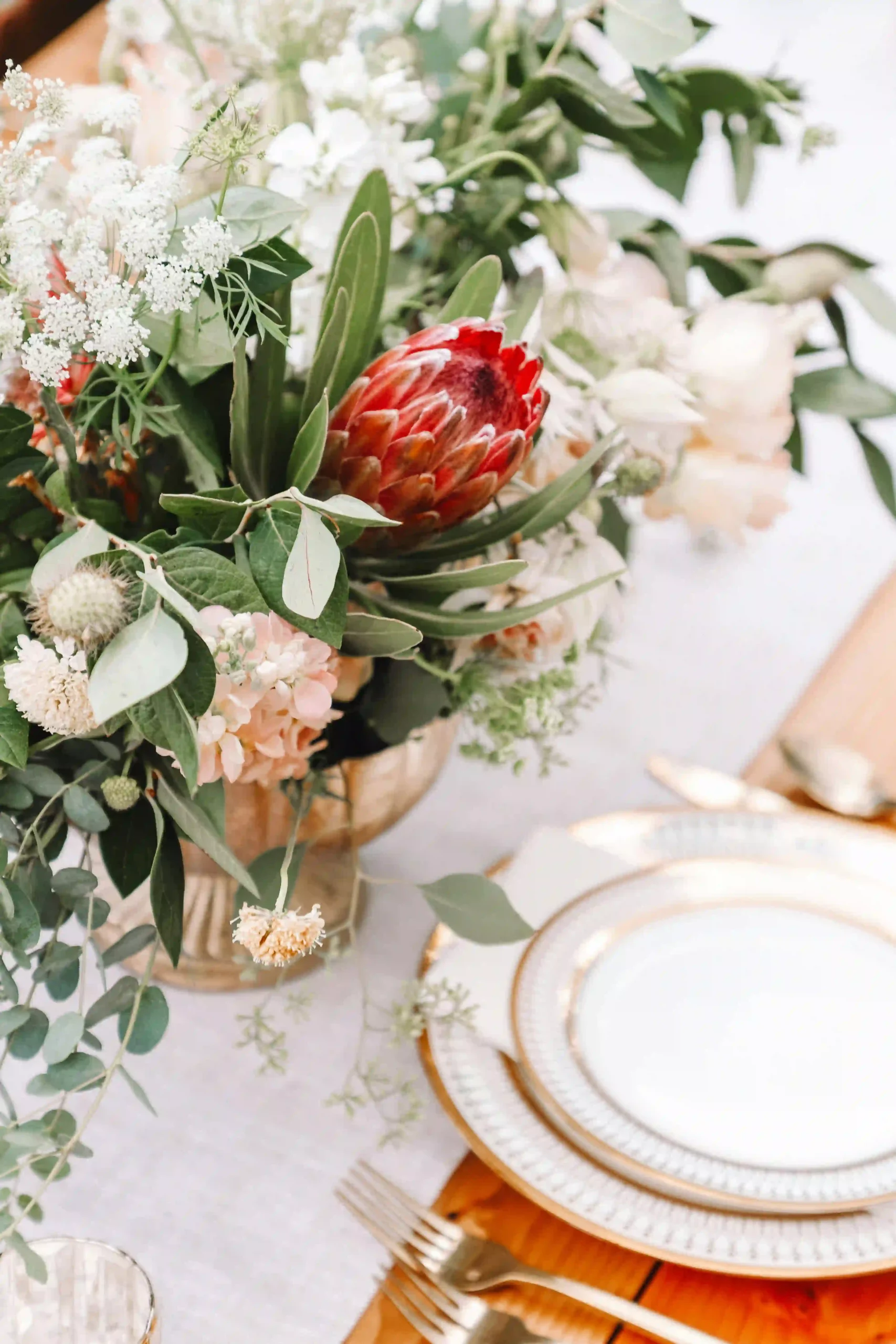 Bord med bröllopsblommor och porslin detaljerat med guld