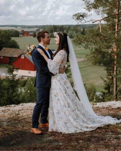 Glatt brudpar med fin grön utsikt i bakgrunden